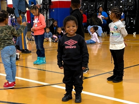 a young boy smiles during an event at the gym